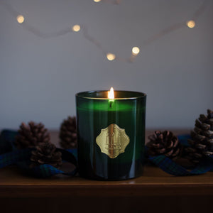 Clause candle burning in green jar